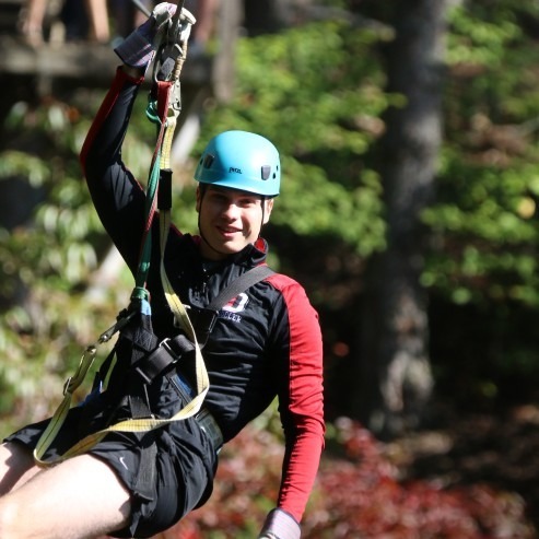 A guest in a helmet and harness on the Ocoee zipline canopy tour